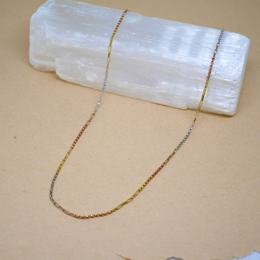 14k tri-color gold chain featuring yellow, white, and rose gold sections with a polished finish and secure lobster clasp, offering a unique and versatile multi-tonal look.
