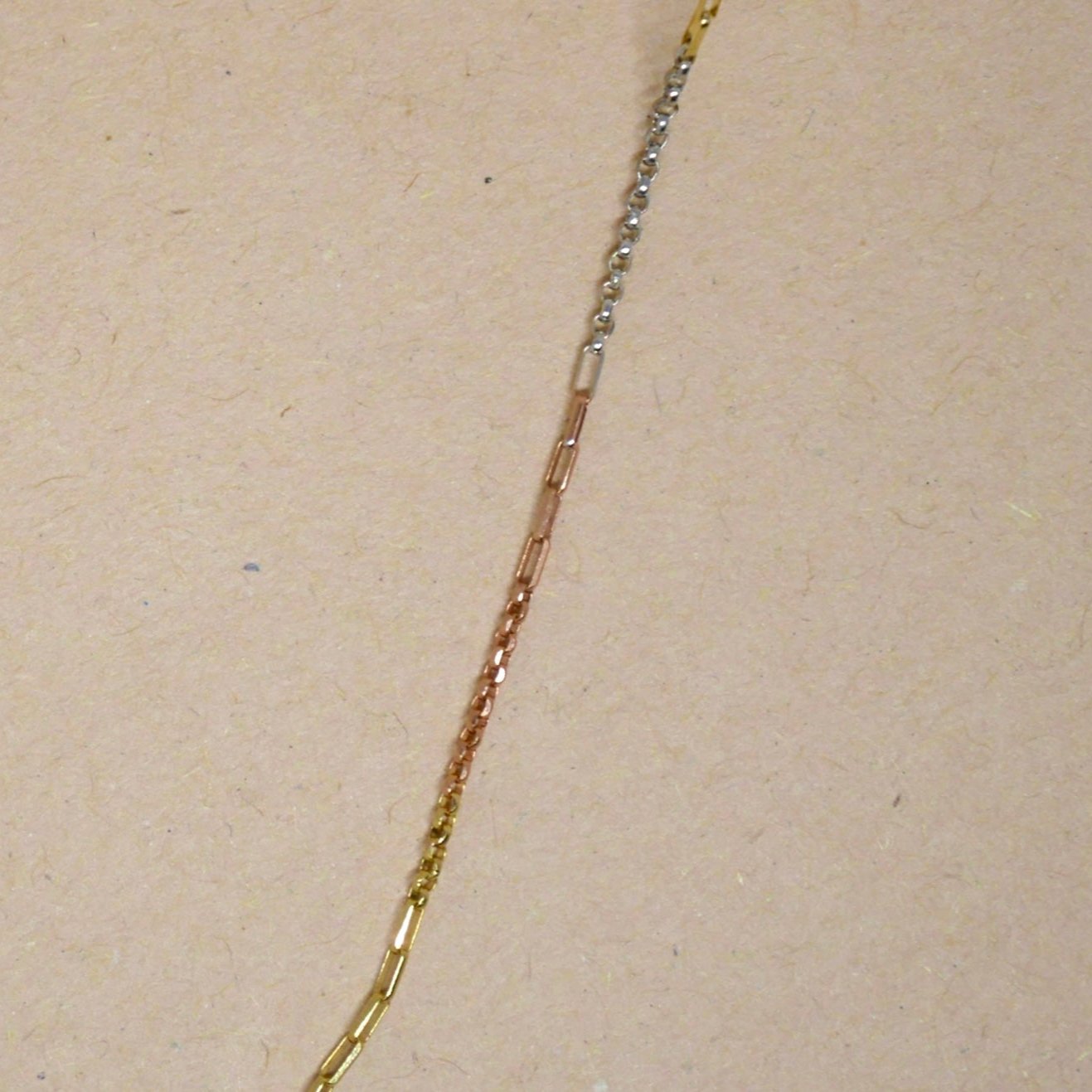 14k tri-color gold chain featuring yellow, white, and rose gold sections with a polished finish and secure lobster clasp, offering a unique and versatile multi-tonal look.